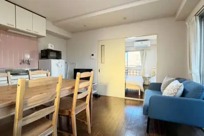 a kitchen and dining room with a table and a blue couch at Sun white Gyoutoku 301 in Tokyo
