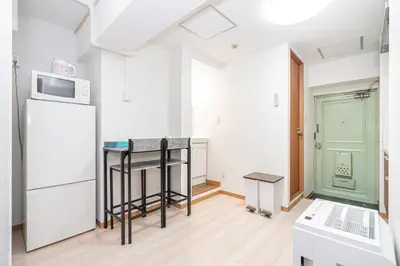a kitchen with a table and a microwave and a refrigerator at Ikebukuro East Exit, 2BR in Tokyo