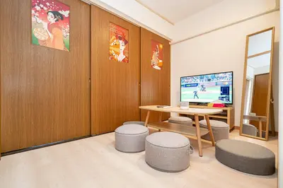 a room with a table and stools and a television at Ikebukuro East Exit, 2BR in Tokyo