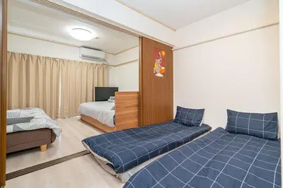 a bedroom with two beds and a tv in it at Ikebukuro East Exit, 2BR in Tokyo