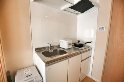 a small kitchen with a sink and a microwave at QU201 Edogawa Japanese Style Apartment 201 has direct access to Akihabara and Shinjuku, with convenient transportation and free WiFi in Tokyo
