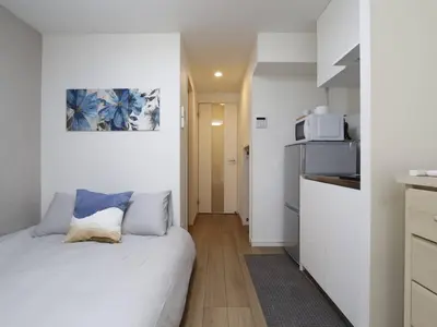 a small room with a bed and a kitchen at Shinjuku新宿近新建公&干湿分离&智能马桶&浴室烘干机能&高速无限制网路&最近地铁步行8分钟BE102 in Tokyo