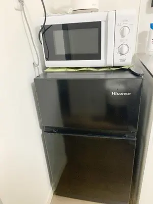 a microwave oven sitting on top of a refrigerator at Shinjuku新宿近新建公&干湿分离&智能马桶&浴室烘干机能&高速无限制网路&最近地铁步行8分钟BE102 in Tokyo