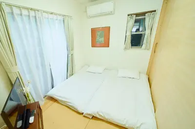 a small bedroom with a bed and a window at Shinjuku 'Deep Lane' Villa in Tokyo
