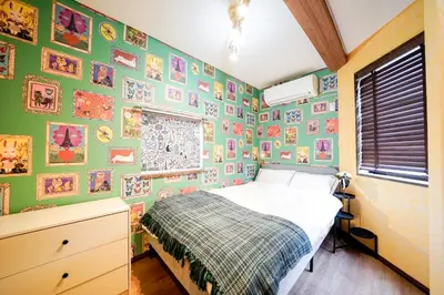 a bedroom with a bed and a wall of pictures at \u6075\u6bd4\u5bff\u5e83\u5c3e\u30a8\u30ea\u30a2\u3000\u8907\u6570\u5bdd\u5ba4\u30c8\u30a4\u30ec\u3000\u30ad\u30c3\u30c1\u30f3\u8a2d\u5099\u5145\u5b9f in Tokyo