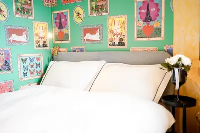 a bedroom with a white bed and a green wall with pictures at \u6075\u6bd4\u5bff\u5e83\u5c3e\u30a8\u30ea\u30a2\u3000\u8907\u6570\u5bdd\u5ba4\u30c8\u30a4\u30ec\u3000\u30ad\u30c3\u30c1\u30f3\u8a2d\u5099\u5145\u5b9f in Tokyo