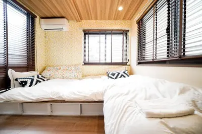 a bedroom with a bed in a room with windows at \u6075\u6bd4\u5bff\u5e83\u5c3e\u30a8\u30ea\u30a2\u3000\u8907\u6570\u5bdd\u5ba4\u30c8\u30a4\u30ec\u3000\u30ad\u30c3\u30c1\u30f3\u8a2d\u5099\u5145\u5b9f in Tokyo