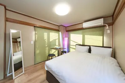 a bedroom with a white bed and a window at \u30db\u30c6\u30eb\u516b\u5e83 in Tokyo