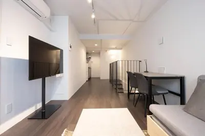 a living room with a flat screen tv on a wall at Lega land\u5e61\u30f6\u8c37 in Tokyo