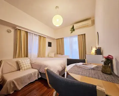 a hotel room with two beds and a table and chairs at AsahiStay -Shinjuku, Self check in, Well located house in Tokyo