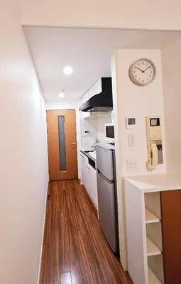 a small kitchen with a clock on the wall at AsahiStay -Shinjuku, Self check in, Well located house in Tokyo