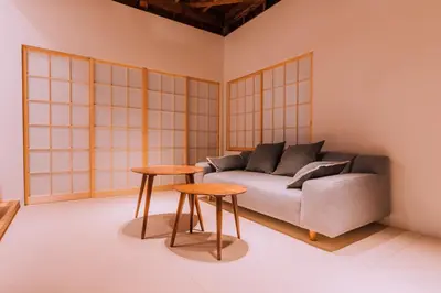 a living room with a couch and two tables at One Harajuku: Private Oasis in Tokyo