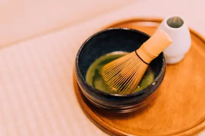a whisk in a black bowl on a wooden plate at One Harajuku: Private Oasis in Tokyo