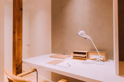 a desk with a lamp and a book on it at One Harajuku: Private Oasis in Tokyo