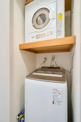 a washer and dryer on a shelf above a washing machine at \u5e83\u3005130\u5e73\u7c73 \u6700\u592713\u540d \u99c5\u5f92\u6b694\u5206 10Gwifi \u591c\u306e\u30d1\u30fc\u30c6\u30a3\u30fc\u3068\u98f2\u307f\u4f1a\u7981\u6b62 in Tokyo