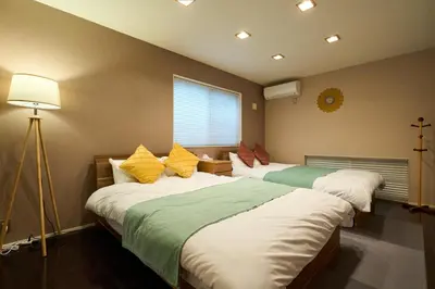 a bedroom with two beds and a window at \u5e83\u3005130\u5e73\u7c73 \u6700\u592713\u540d \u99c5\u5f92\u6b694\u5206 10Gwifi \u591c\u306e\u30d1\u30fc\u30c6\u30a3\u30fc\u3068\u98f2\u307f\u4f1a\u7981\u6b62 in Tokyo