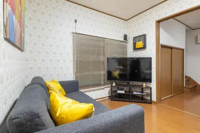 a living room with a couch and a tv at KiraKira House Elegant 3BR on Yamanote Line in Tokyo