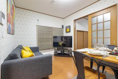 a living room with a couch and a table and a television at KiraKira House Elegant 3BR on Yamanote Line in Tokyo