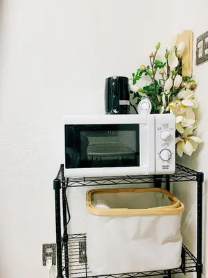 a microwave on a stand with a vase of flowers at \u6da9\u8c37\u4e2d\u5fc3 ! \u6da9\u8c37\u5341\u5b57\u8def\u53e3 109 Shibuya scramble crossing \u9ad8\u901f\u65e0\u9650\u5236\u7f51\u7edc509 in Tokyo