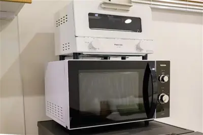 a microwave with a toaster oven on top of it at Komei Hotel/5min to station/Direct access to Narita and Haneda/Asakusa/Sky tree in Tokyo