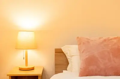 a bedroom with a bed with a lamp on a night stand at Komei Hotel/5min to station/Direct access to Narita and Haneda/Asakusa/Sky tree in Tokyo
