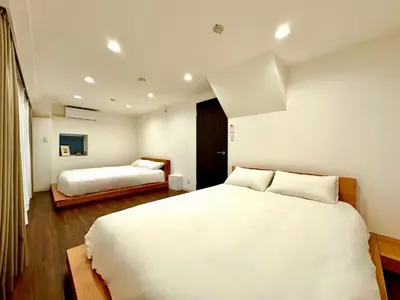 a white bedroom with two beds in it at LoveTokyo Maisonette Terrace in Tokyo