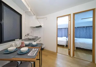 a small kitchen with a table and a bedroom at Aurora 3 in Tokyo