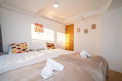 two beds in a bedroom with white walls at Aurora 3 in Tokyo