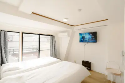 a bedroom with a bed and a tv on the wall at Aurora 3 in Tokyo