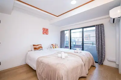 a bedroom with two beds and a large window at Aurora 3 in Tokyo