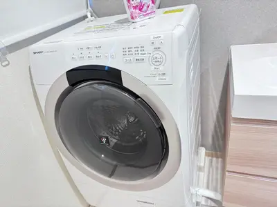 a white washing machine sitting in a room at JW-One in Tokyo