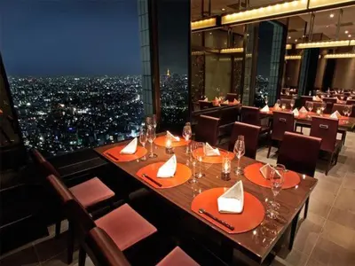 a restaurant with a view of a city at night at JW-One in Tokyo