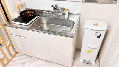 a small kitchen with a sink and a trash can at JW-One in Tokyo