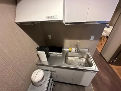 a small kitchen with a sink in a room at Sky hotel 06#\u775b\u7a7a\u5854\u70ed\u95e8\u65c5\u6e38\u666f\u533a \u6700\u8fd1\u8f66\u7ad9\u6b65\u884c3\u5206\u949f \u673a\u573a\u76f4\u8fbe \u5468\u8fb9\u6709\u4fbf\u5229\u5e97 \u5546\u573a \u6e29\u6cc9 \u8d2d\u7269\u9910\u996e\u65b9\u4fbf in Tokyo
