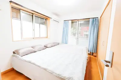 a bedroom with a bed and two windows at takadababa 4 mins walk/新宿圈! 高速无限制网路/车站步行4分钟新装修公寓102 in Tokyo