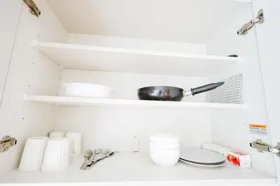 a kitchen counter with white shelves and a sink at takadababa 4 mins walk/新宿圈! 高速无限制网路/车站步行4分钟新装修公寓102 in Tokyo