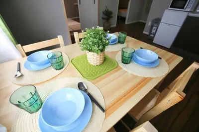 a table with plates and hats and a potted plant at QU101 Edogawa Japanese Style Apartment 101 has direct access to Akihabara and Shinjuku, with convenient transportation and free WiFi in Tokyo