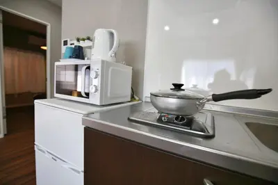 a kitchen counter with a pot and a microwave at QU101 Edogawa Japanese Style Apartment 101 has direct access to Akihabara and Shinjuku, with convenient transportation and free WiFi in Tokyo