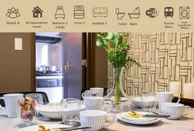 a table with white dishes and a vase with flowers at Premier suite Nishiazabu Roppongi front in Tokyo
