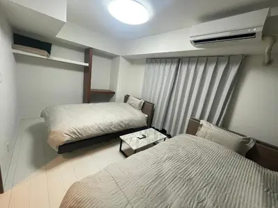 a small room with two beds and a window at CAlMU ASAKUSA IMADO HOTEL ASAKUSA UENO IMADOZINZYA TOKYOSKYTREE HANEDA NARITA GINZA TOKYOSTATION Direct \u6d45\u8349\u4e0a\u91ce\u6771\u4eac\u30b9\u30ab\u30a4\u30c4\u30ea\u30fc \u6210\u7530\u7a7a\u6e2f\u7fbd\u7530\u7a7a\u6e2f\u6771\u4eac\u99c5\u76f4\u884c\u30d0\u30b9 \u96fb\u8eca\u4fbf\u5229 in Tokyo