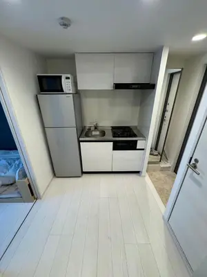 a small kitchen with a stove and a microwave at CAlMU ASAKUSA IMADO HOTEL ASAKUSA UENO IMADOZINZYA TOKYOSKYTREE HANEDA NARITA GINZA TOKYOSTATION Direct \u6d45\u8349\u4e0a\u91ce\u6771\u4eac\u30b9\u30ab\u30a4\u30c4\u30ea\u30fc \u6210\u7530\u7a7a\u6e2f\u7fbd\u7530\u7a7a\u6e2f\u6771\u4eac\u99c5\u76f4\u884c\u30d0\u30b9 \u96fb\u8eca\u4fbf\u5229 in Tokyo