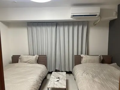 a hotel room with two beds and a air conditioner at CAlMU ASAKUSA IMADO HOTEL ASAKUSA UENO IMADOZINZYA TOKYOSKYTREE HANEDA NARITA GINZA TOKYOSTATION Direct \u6d45\u8349\u4e0a\u91ce\u6771\u4eac\u30b9\u30ab\u30a4\u30c4\u30ea\u30fc \u6210\u7530\u7a7a\u6e2f\u7fbd\u7530\u7a7a\u6e2f\u6771\u4eac\u99c5\u76f4\u884c\u30d0\u30b9 \u96fb\u8eca\u4fbf\u5229 in Tokyo