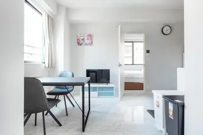 a living room with a table and chairs and a bedroom at SOLASIA residence \u5317\u4e0a\u91ce in Tokyo