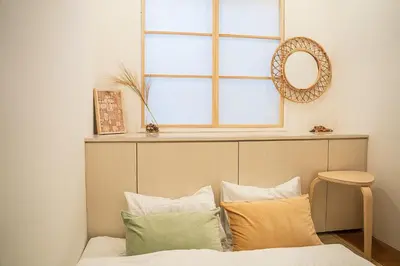 a bedroom with a bed with pillows and a window at Business Hotel Kankokukan - Vacation STAY 45862v in Tokyo