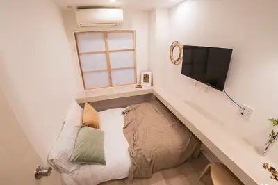 a small room with a couch and a flat screen tv at Business Hotel Kankokukan - Vacation STAY 45862v in Tokyo