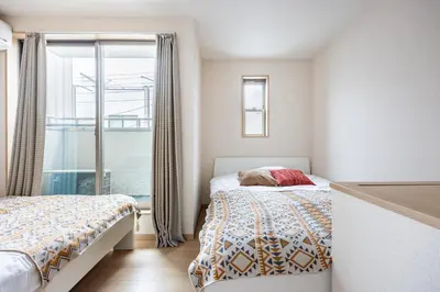 a bedroom with two beds and a window at CROWN \u8d8a\u4e2d\u5cf6 in Tokyo