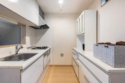 a kitchen with white cabinets and a sink at CROWN \u8d8a\u4e2d\u5cf6 in Tokyo