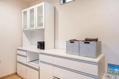 a kitchen with white cabinets and a shelf at CROWN \u8d8a\u4e2d\u5cf6 in Tokyo