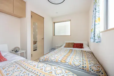 a bedroom with two beds and a window at CROWN \u8d8a\u4e2d\u5cf6 in Tokyo