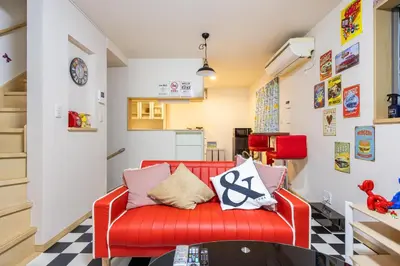 a living room with a red couch and a checkered floor at CROWN \u8d8a\u4e2d\u5cf6 in Tokyo